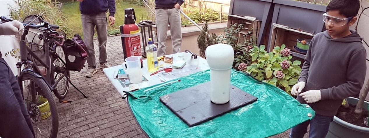 Mehrere Zuschauer und Akteure rund um den Tischversuch zur Elefantenzahnpasta